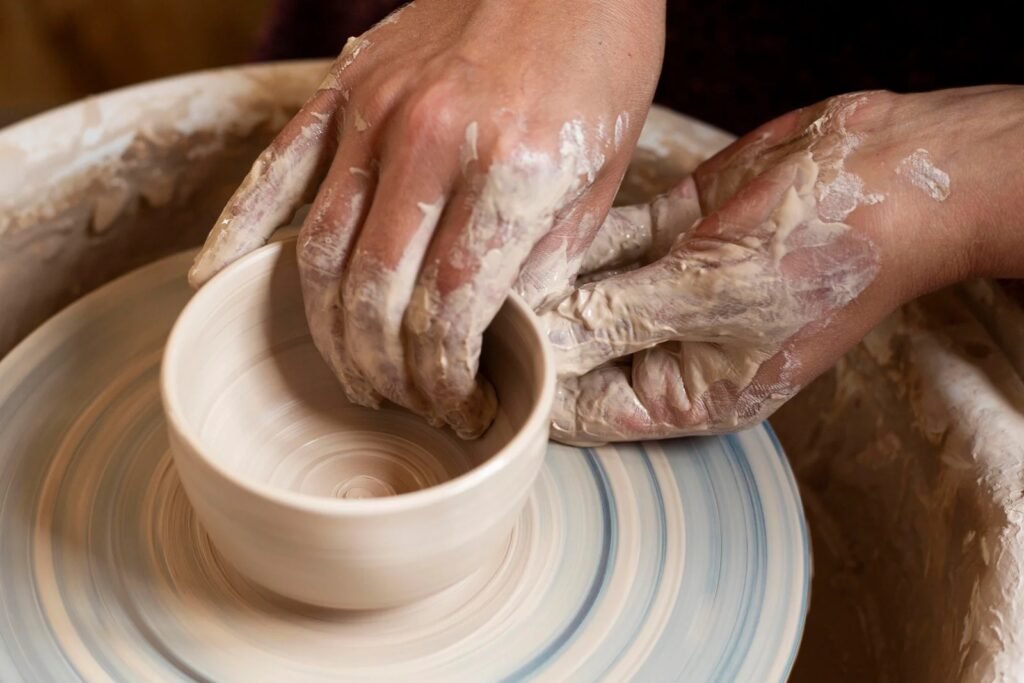 Artisan modeling clay on a potter's wheel at Harnile