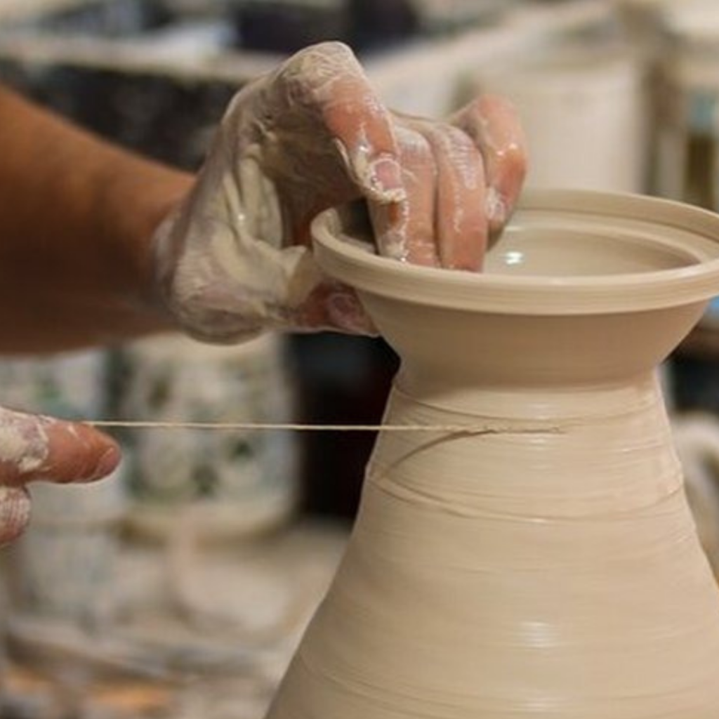 Close-up of an artisan's hands shaping a ceramic bowl at Harnile's workshop